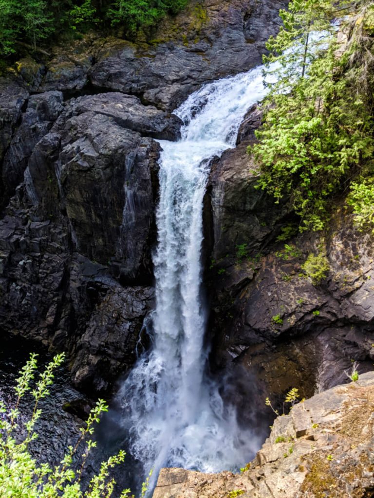 A large and powerful waterfall drops into a canyon