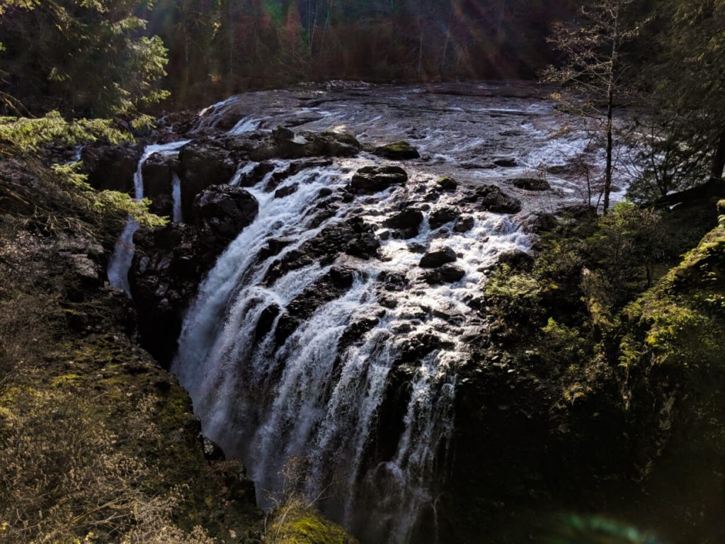 Wide multi-stream waterfall falling into deep canyon below