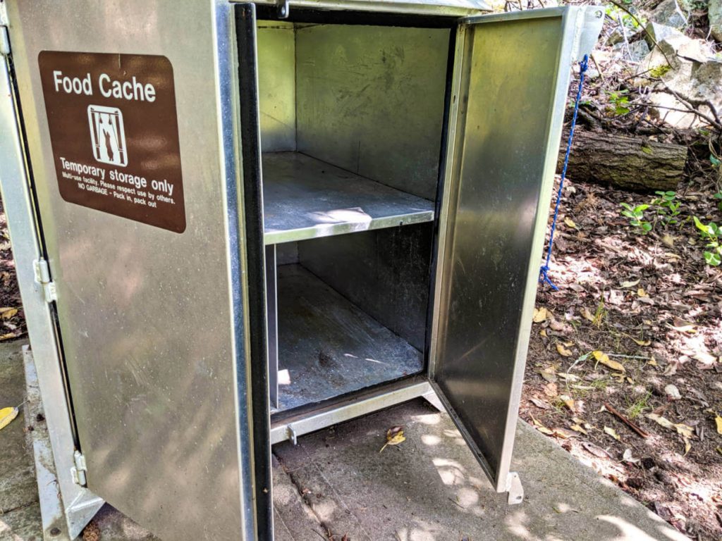 Looking inside a metal food cache with shelves and open doors