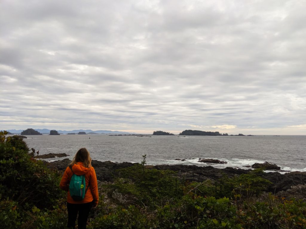 Gemma stands with her back to camera, looking in the distance to islands in the pacific